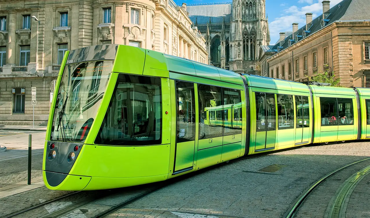 A green tram in a city square