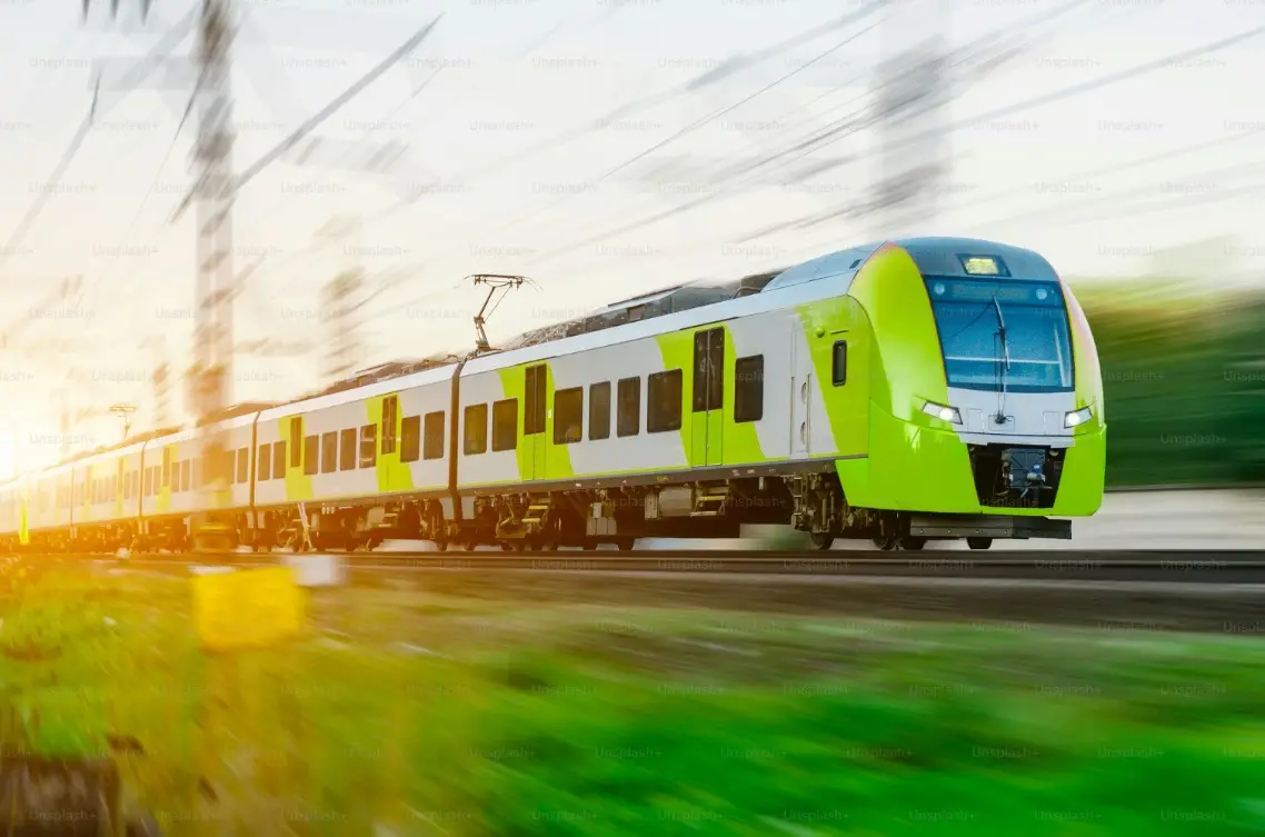 A modern green and white train speeding through countryside