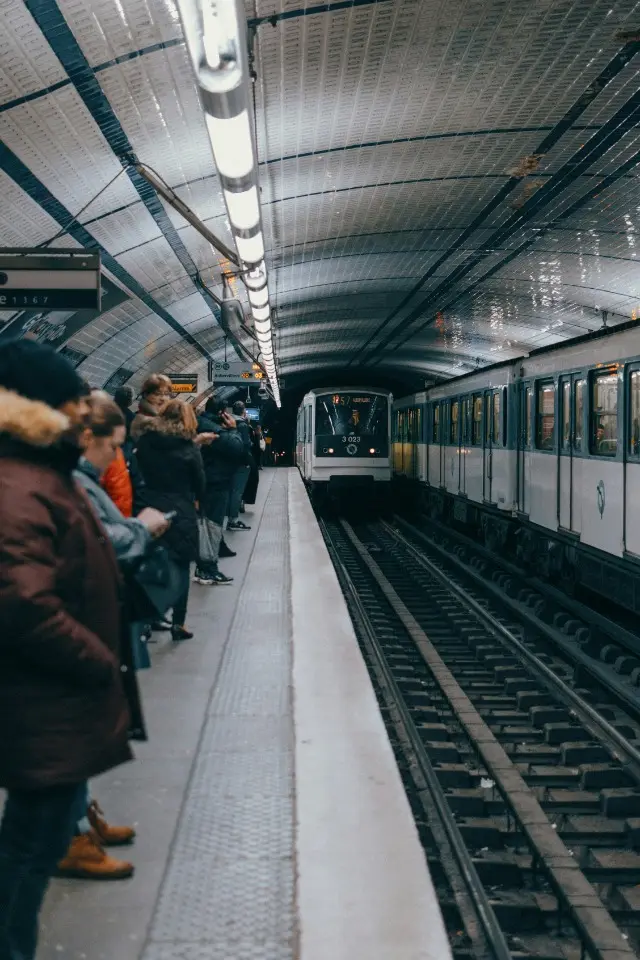 Passengers waiting on a metro platform as a train arrives